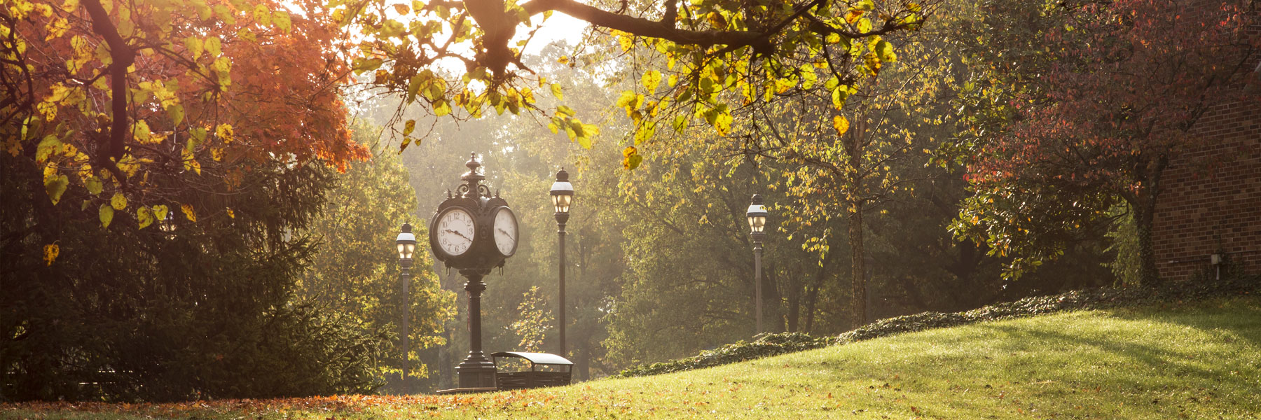 IU Southeast's McCullough plaza clock tower surrounded by lamp posts and fall leaves