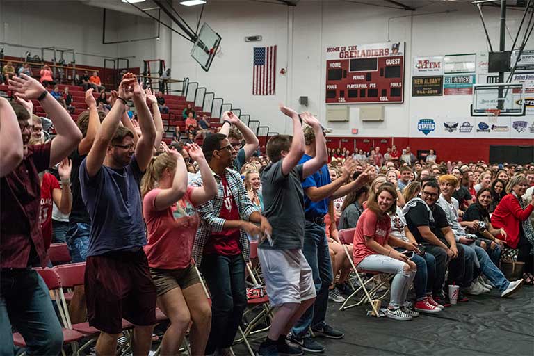 Large crowd of IU Southeast students in a gymnasium performing the wave