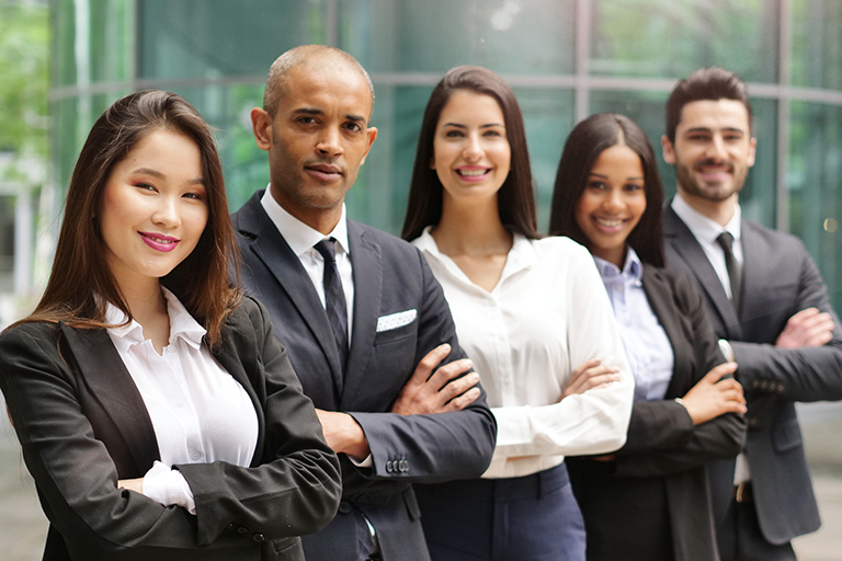 Group of diverse people in professional business attire crossing arms and smiling