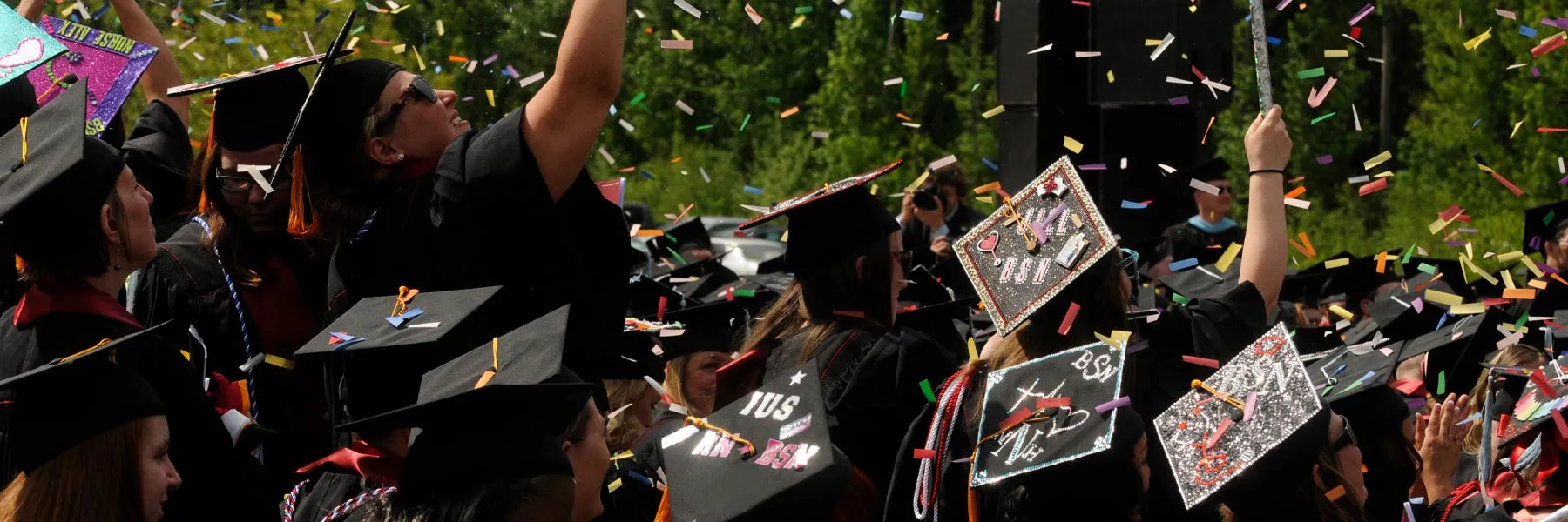 Graduates celebrating as confetti falls