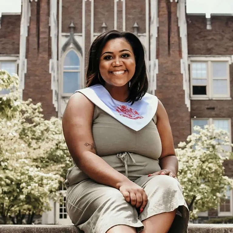 IU Southeast Honors Program student De'Anna Brooks sitting on steps and smiling