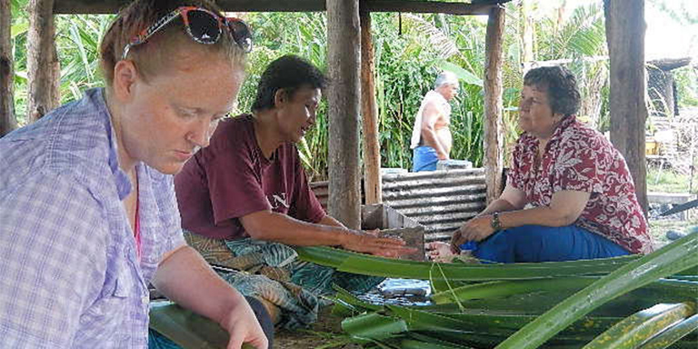 Faculty member and student working and talking with Samoan woman