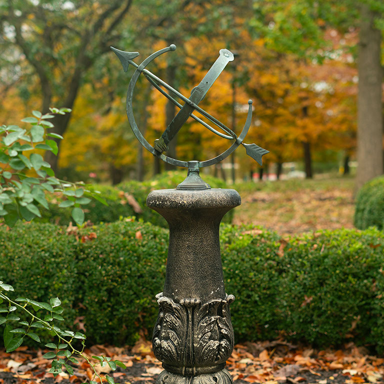 A sculpture of an arrow on IU Southeast's campus surrounded by fall leaves